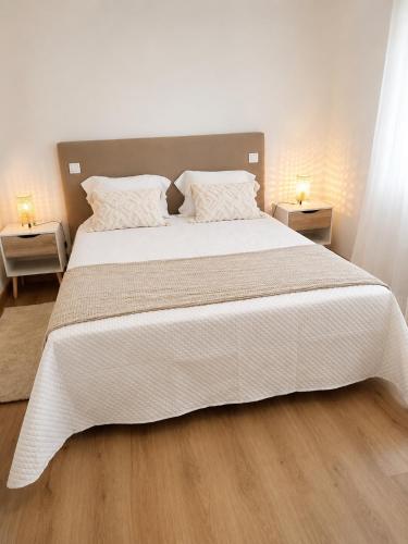 a bedroom with a large white bed with two night stands at Casa com Alma by LovelyStay in Fátima