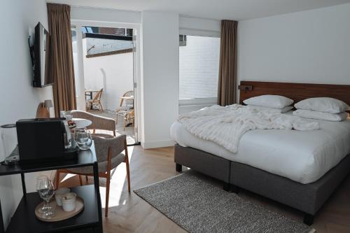 a bedroom with a bed and a table with a television at Residence Paradis in Zandvoort