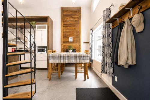 a kitchen and dining room with a table and a staircase at Chalet Chic et Spa - St-Come in Saint Come