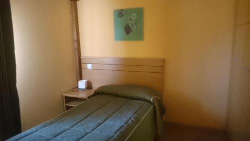 a small bedroom with a bed and a small table at Hotel Santuario Urkiola - Lagunetxea in Urquiola
