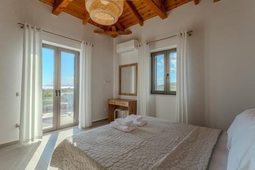 a white bedroom with a bed and a window at Sofia's Villa in Riglia