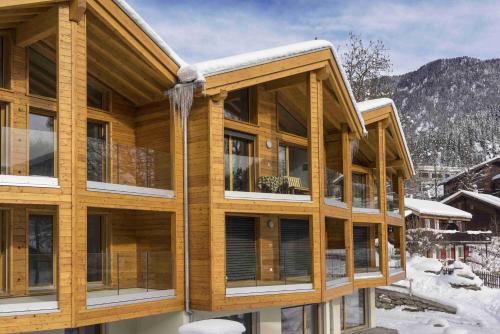 drewniany dom z śniegiem na dachu w obiekcie Bergquell B w mieście Blatten bei Naters
