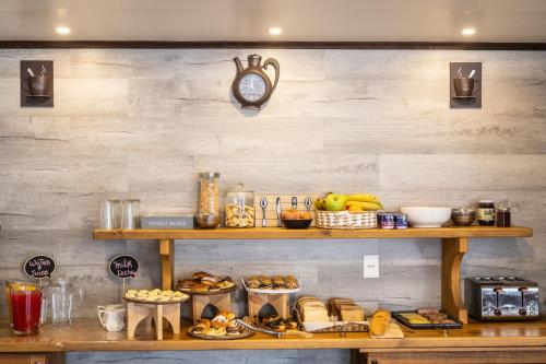 a shelf with food and a clock on a wall at Nikos II Adventure in Puerto Natales