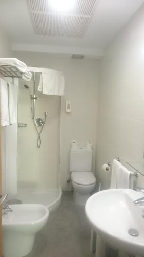 een witte badkamer met een toilet en een wastafel bij Hotel Santuario Urkiola - Lagunetxea in Urquiola