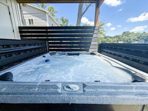 a hot tub in the back of a house at Lakeside, Water-view, 7 miles to Ark, 4BR for 14 in Williamstown