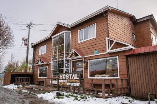 a wooden house with a sign in front of it at Nikos II Adventure in Puerto Natales