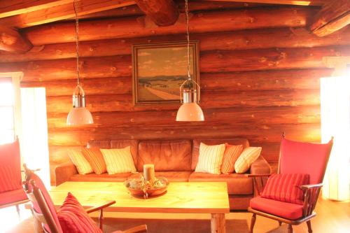 a living room with a couch and a table at Dein Blockhaus in Gollenberg