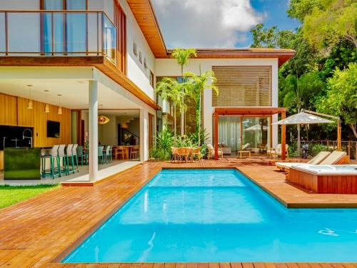 a swimming pool in the backyard of a house at Green House Praia do Forte- 4 Suítes Premium in Mata de Sao Joao