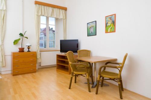 a dining room with a table and chairs and a television at Městský Hotel Dorinka in Hostinné