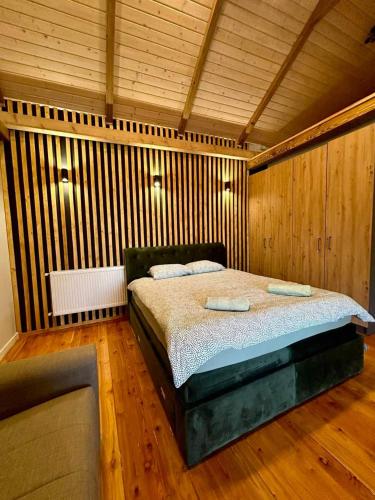 a bedroom with a bed in a room with wooden walls at Mount House Mavrovo in Mavrovo