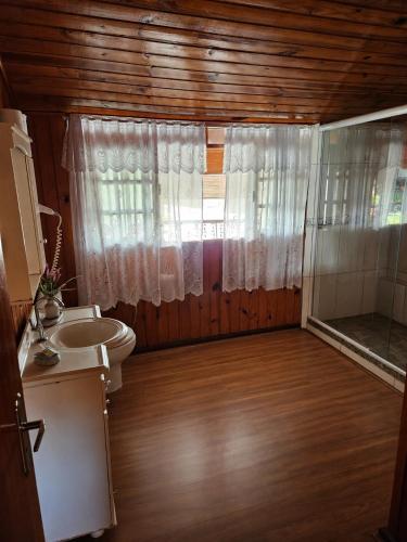 a bathroom with a sink and a toilet and a window at Pousada Bem Te Vi Lumiar in Lumiar