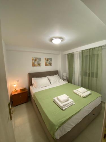 a bedroom with a bed with green sheets and white pillows at Kurti Home in Agia Triada