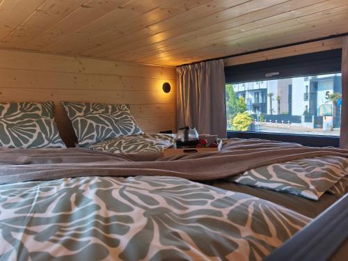 a bedroom with two beds and a window at Tiny Vinkel - Domki Tiny House Jastarnia in Jastarnia
