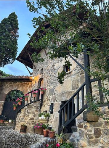 a stone building with potted plants and a fence at LITTLE TOWER in Potes