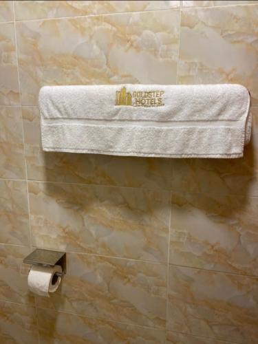 a towel hanging on a wall in a bathroom at Goldstep Hotel Asaba in Asaba