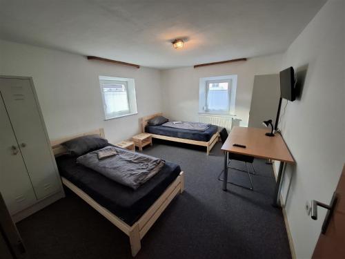 a bedroom with two beds and a desk and a table at Zum oid'n Leidlhof in Berching