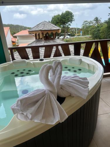 a jacuzzi tub with two towels in it at Résidence Simona Premium in Deshaies
