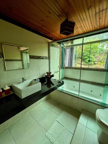a bathroom with a sink and a mirror and a toilet at Sitio Tashi Delek in Cavalcante