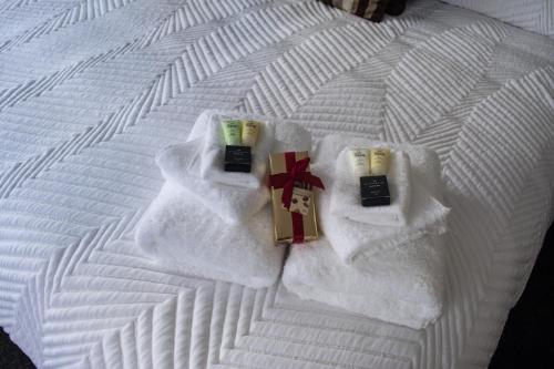 a bed with white towels and candles on it at Madsen Retreat in Penguin