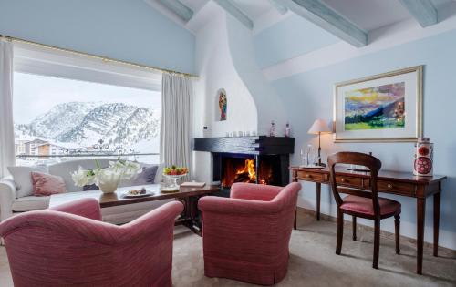 a living room with a desk and a fireplace at Thurnher's Alpenhof in Z&uuml;rs am Arlberg