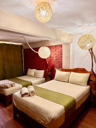 a bedroom with two beds and two chandeliers at Hotel Spa Chignahuapan Mágico in Chignahuapan