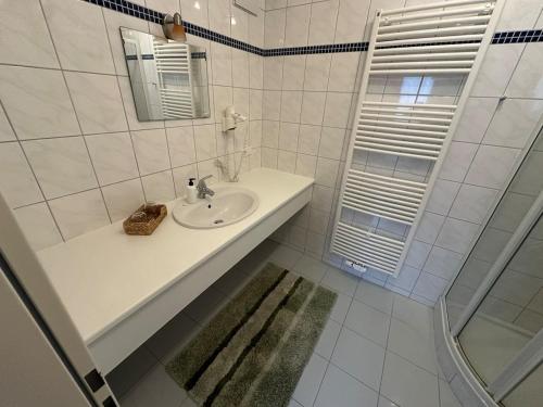 a white bathroom with a sink and a mirror at Max and Moritz Top 9 in Liebenau