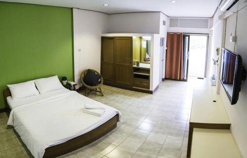 um quarto com uma cama e uma parede verde em บ้านภูมิพันธ์ em Hat Yai