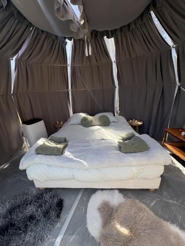 a bed in a tent with towels on it at la bulle d'Astrée in Le Tronchet