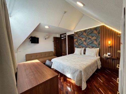 a bedroom with a bed and a couch at Casa Hidalgo Ecuador in Cumbayá