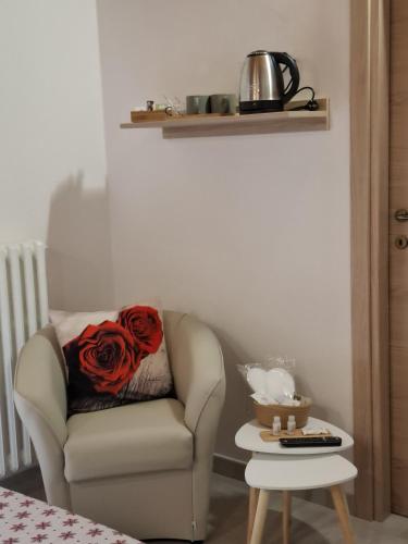 a red rose sitting on a chair in a room at Mondo D'Oro in Macugnaga