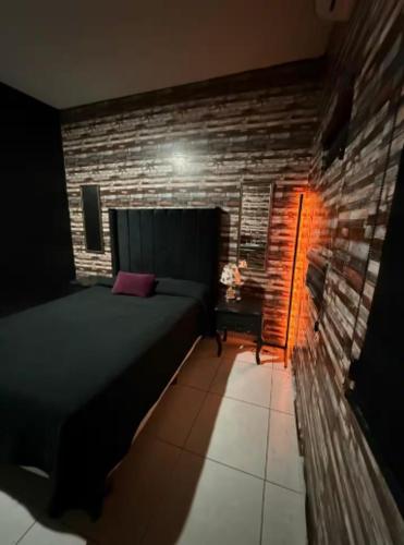 a bedroom with a bed and a brick wall at Feng tower in Culiacán