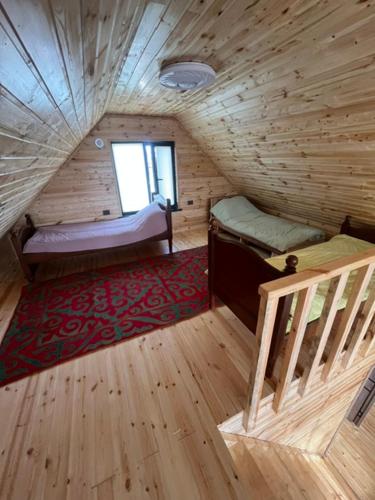 a room with two beds and a staircase in a log cabin at Barnhouse in Bosteri