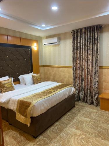 a bedroom with a large bed in a room at Goldstep Hotel Asaba in Asaba