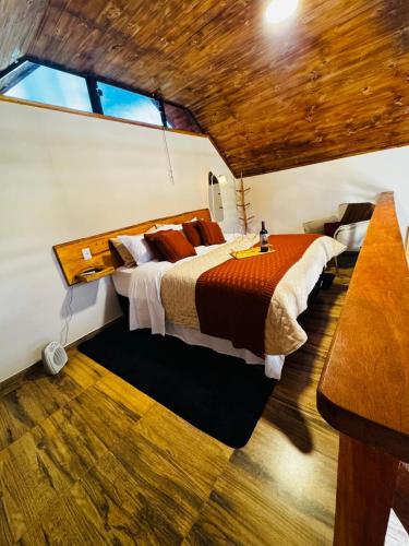 a bedroom with a large bed in a room at Chalé Recanto Figueira in Camanducaia