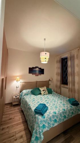 a bedroom with a bed with a blue comforter at argentario home in Porto Santo Stefano