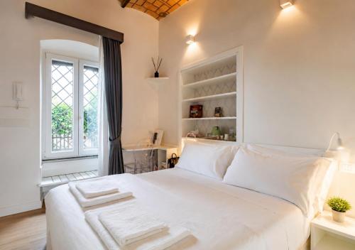 a white bedroom with a large white bed and a window at Ponte Milvio Roma Elegance Room & Private Parking in Rome
