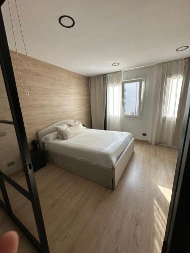 a bedroom with a white bed and a window at Urban Loft Rosal - parking privado in Oviedo