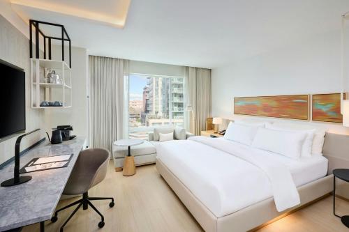 a white bedroom with a large white bed and a desk at The Pearle Hotel & Spa, Autograph Collection in Burlington