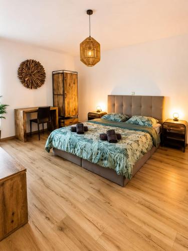 a bedroom with a bed and a wooden floor at Escale Tout Confort Maison entière Parking gratuit Proche Aéroport Charleroi in Charleroi