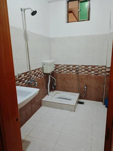a bathroom with a toilet and a sink and a tub at The Abbott Crown Hotel Rajwal in Kāgān