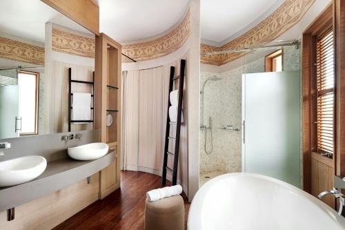 a bathroom with two sinks and a shower at Le Domaine Deva, Series by Marriott in Bourail