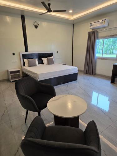 a bedroom with a bed and a table and chairs at Ganga Bliss Riverside in Haridwār
