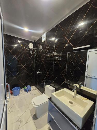 a bathroom with a white sink and a toilet at Ganga Bliss Riverside in Haridwār