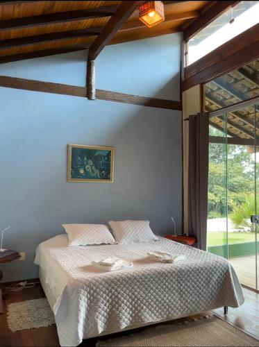 a bedroom with a bed and a large window at Sitio Tashi Delek in Cavalcante