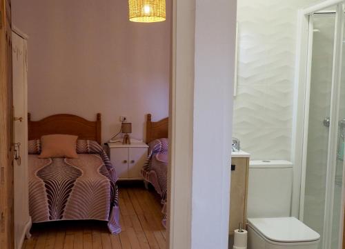 a small room with two beds and a bathroom at Casa Rural Lutia in Andaluz