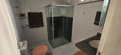 a bathroom with a glass shower and a toilet at Studio Cinza em frente à praia in Aracaju
