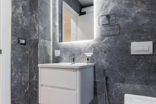 a bathroom with a white sink and a mirror at Ambra & Arber Hotel in Bogovë