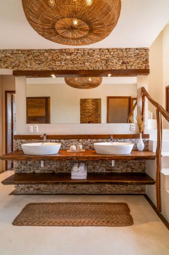 a bathroom with two sinks and a large mirror at Villa Praia - La Villa Group in Jericoacoara