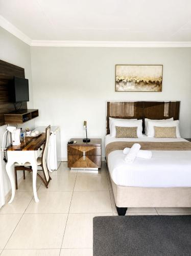 a bedroom with a bed and a desk and a computer at TLMZ Guesthouse in Newcastle