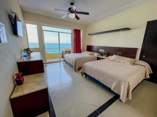 a bedroom with two beds and a view of the ocean at Hotel Bogavante in Barra de Navidad